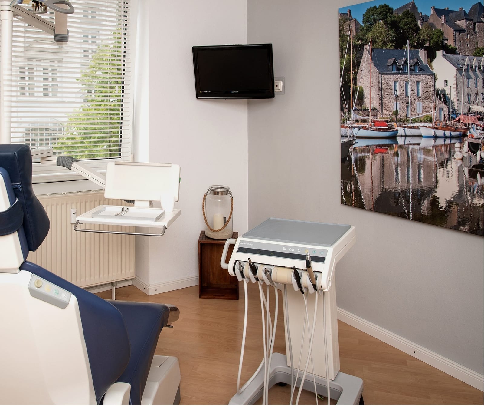 Zweites Behandlungszimmer mit Fenster und Hafenmotiv an der Wand